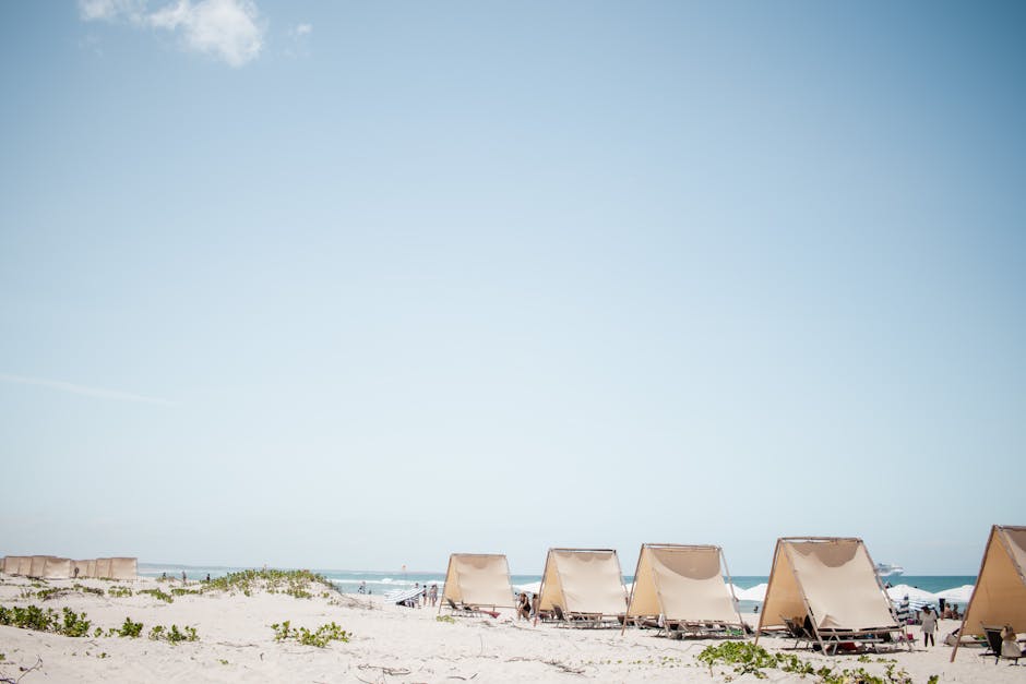 Serene beach scene with tents under a clear blue sky, perfect for a summer getaway.