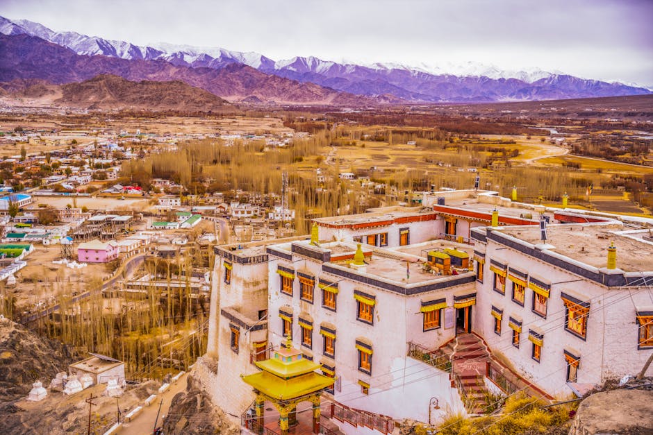 A stunning view of a monastery in Leh with the Himalayan mountains in the background.