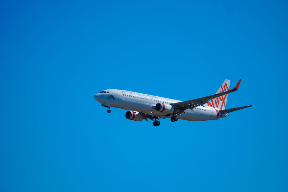 A passenger airplane flying against a cloudless blue sky, mid-flight.