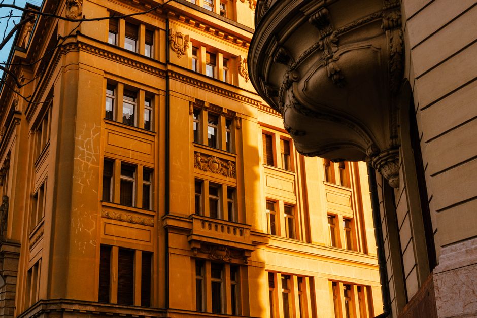 Neoclassical building in Pozsony, Slovakia glowing under warm sunset light, capturing urban elegance.
