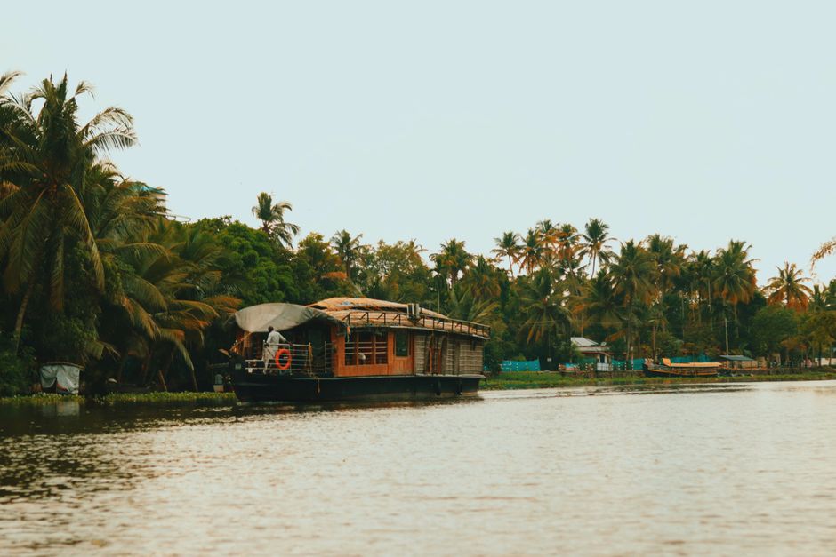Peaceful scene of a traditional houseboat cruising on Kerala's lush backwaters.