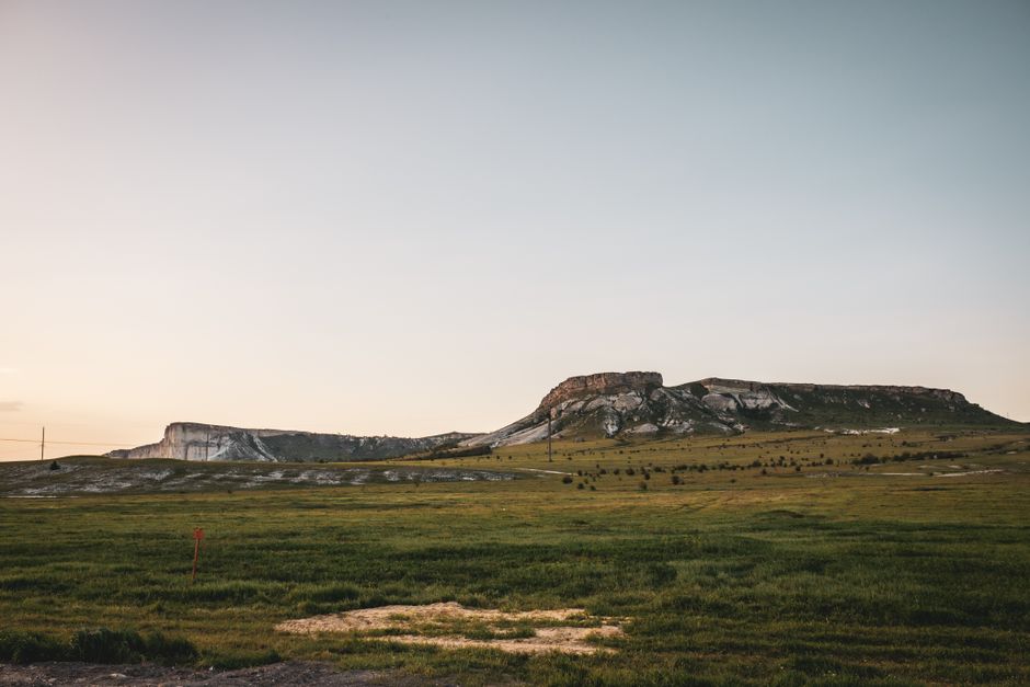 Peaceful grassland and rocky hills under a twilight sky in Керчь, ideal for nature and travel themes.