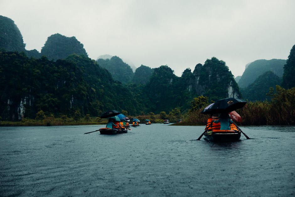 Explore the enchanting karst formations of Ninh Binh, Vietnam on a rainy boat journey.