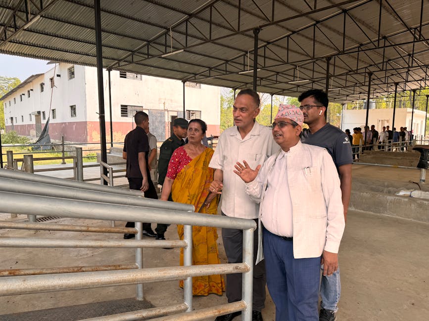 A group of people visiting a rural industrial site, discussing the surroundings.