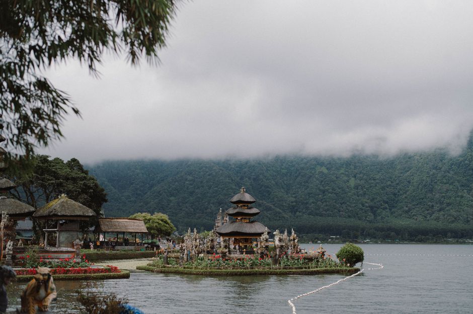 A serene view of the Ulun Danu Beratan Temple surrounded by misty mountains and Lake Beratan.
