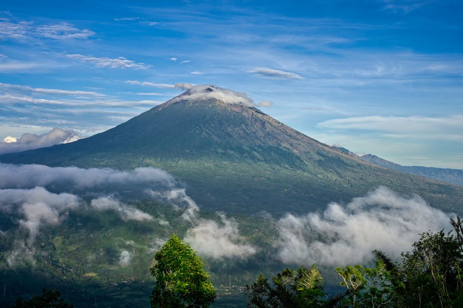 Breathtaking landscape of Mount Agung surrounded by clouds in beautiful Bali, Indonesia.